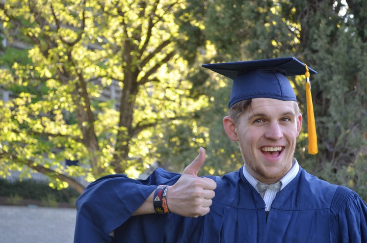 Male graduate giving thumbs up